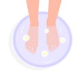 Feminine feet in foot bath with flowers