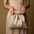 Feminine hand clutches canvas bag, symbolizing support on beige backdrop