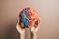 Feminine hands cradle a colorful human brain replica, illustrating the intricate tapestry of neurodiversity, human