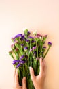 Feminine hands holding bouquet of sea lavender flowers Limonium on pink background. Top view. Copy space