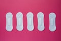 Feminine hygiene pad on a pink background. Concept of feminine hygiene during menstruation. Flat lay, top view