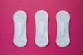 Feminine hygiene pad on a pink background. Concept of feminine hygiene during menstruation. Flat lay, top view