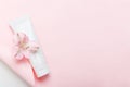 Feminine hygienic product tube on pastel pink background. Shampoo, hand cream, toothpaste white package side view on paper sheet