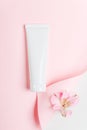 Feminine hygienic product tube on pastel pink background. Shampoo, hand cream, toothpaste white package side view on paper sheet Royalty Free Stock Photo