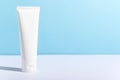 Feminine hygienic product tube on sunny blue background. Shampoo, hand cream, toothpaste white package side view. Skincare, facial