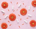 Feminine intimate hygiene set over pink background with orange flowers and petals. Menstruation sanitary soft cotton tampons.