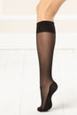 Feminine leg with black knee-highs. Royalty Free Stock Photo