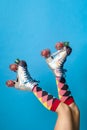 Feminine legs in a roller skates shoes with blue background