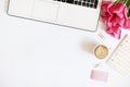 Top view of female worker desktop with laptop, flowers and different office supplies items. Feminine creative design workspace. Royalty Free Stock Photo