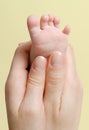 Feminine palm holding a baby foot Royalty Free Stock Photo