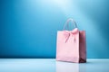 Feminine pink shopping bag with ribbon bow on blue background, springtime or summer sale and Valentine surprise offer promotion