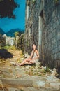 Feminine portrait of young romantic woman sitting on oldest stone road in Old Bar, Montenegro. Summer travelling