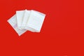 Feminine sanitary napkin, an absorbent item worn by a woman while menstruating, on red background Royalty Free Stock Photo