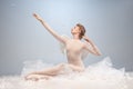 Portrait of pretty, slim beautiful young girl, graceful ballerina in image of angel with wings sitting on cloud isolated Royalty Free Stock Photo