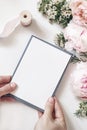 Feminine wedding, birthday mockup scene, composition with pink peonies and rose flowers. Closeup of woman`s hands