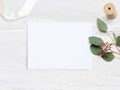 Feminine wedding desktop mock-up with blank paper card and Eucalyptus populus branch on white shabby table background Royalty Free Stock Photo