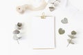 Feminine wedding desktop stationery mockup with blank greeting card, dry eucalyptus leaves, silk ribbon and golden