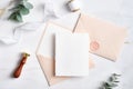 Feminine wedding invitation. Blank paper card mockup, pink envelopes, silk ribbon, eucalyptus, wax seal stamp on marble table. Royalty Free Stock Photo