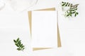 Feminine wedding stationery, desktop mock-up scene. Blank greeting card, craft envelope, baby`s breath flowers, silk Royalty Free Stock Photo