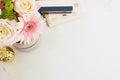 Feminine workplace concept in flat lay style with, flowers, golden pineapple, notebooks on white marble background. Top view, brig