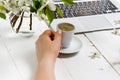 Feminine workplace concept. Freelance fashion comfortable femininity workspace  with laptop, coffee, flowers on white background Royalty Free Stock Photo