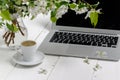 Feminine workplace concept. Freelance fashion comfortable femininity workspace  with laptop, coffee, flowers on white background Royalty Free Stock Photo