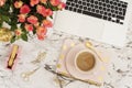 Feminine workplace concept. Freelance workspace in flat lay style with laptop, coffee, flowers, golden pineapple, notebook and pap