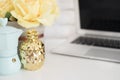 Feminine workplace concept. Freelance workspace with laptop, flowers, golden pineapple. Blogger working. Bright, yellow and gold.