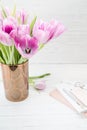 Feminine workspace. Bright and airy desk top with notepad and flowers. Vertical Royalty Free Stock Photo