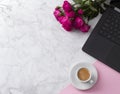 Feminine workspace with laptop computer, bouquet of roses and coffee on a marble table. Royalty Free Stock Photo