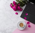 Feminine workspace with laptop computer, bouquet of roses and coffee on a marble table. Royalty Free Stock Photo