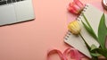 Feminine workspace with laptop, notebook and flowers decorated on the pink table Royalty Free Stock Photo