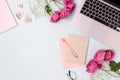 Feminine workspace with laptop, rose flowers and office supply Royalty Free Stock Photo