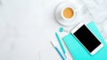 Feminine workspace with mint paper notebook, cup of coffee, office supplies, smartphone on marble desk. Flat lay, top view, copy Royalty Free Stock Photo