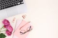 Feminine workspace for online work with laptop, rose flowers, stationery Royalty Free Stock Photo