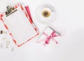 Feminine workspace with paper blank, golden office stationery, present box, cup of coffee. Flat lay, top view
