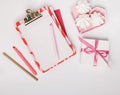 Feminine workspace with paper blank, office stationery,sweets, present box. Flat lay, top view