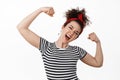 Feminism, women rights and empowerment concept. Strong and free young brunette woman flex biceps, showing strength