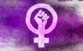 Feminist icon with clenched fist, drawn in white on a purple background. Watercolour effect