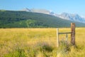 Fence along field of grasses in Glacial mountains. Royalty Free Stock Photo