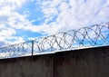 Fence with barbed wire against a blue sky background. Security concept, forbidden territory, entry prohibited/no entry Royalty Free Stock Photo