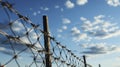 A fence of barbed wire against a blue sky with cirrus clouds. Chains on the Horizon. Generative AI