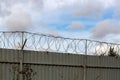 Fence with barbed wire against the sky Royalty Free Stock Photo