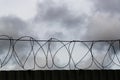 Fence with barbed wire against the sky Royalty Free Stock Photo