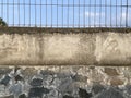 Fence with barbed wire blue sky background. Barbed iron fence with small bars Royalty Free Stock Photo