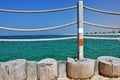 Fence on the beach close-up. The railing is made of unpainted wood and thick braided ropes.