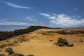 Fence of black vocanic stone contrast with the orange dunes Royalty Free Stock Photo