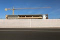 Fence consisting of plastic sheeting at the roadside. Building under construction with tower crane above Royalty Free Stock Photo