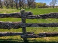 Log fence by green grassy meadow and woods Royalty Free Stock Photo