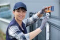 fence construction female worker check level metal post Royalty Free Stock Photo